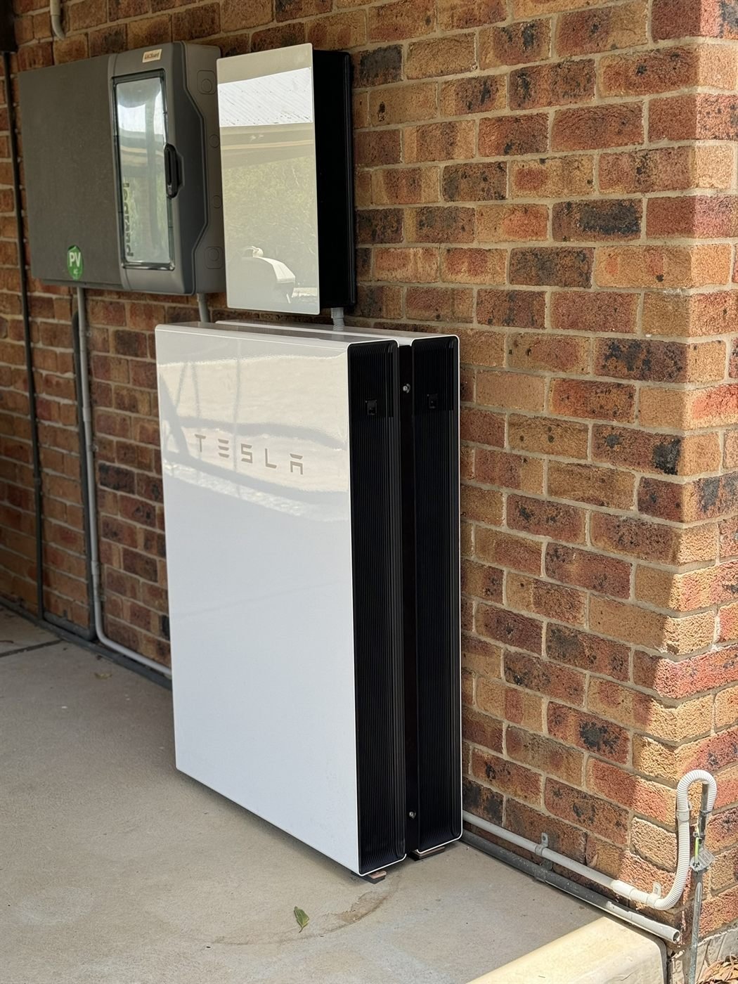 Tesla Powerwall battery installed on brick wall