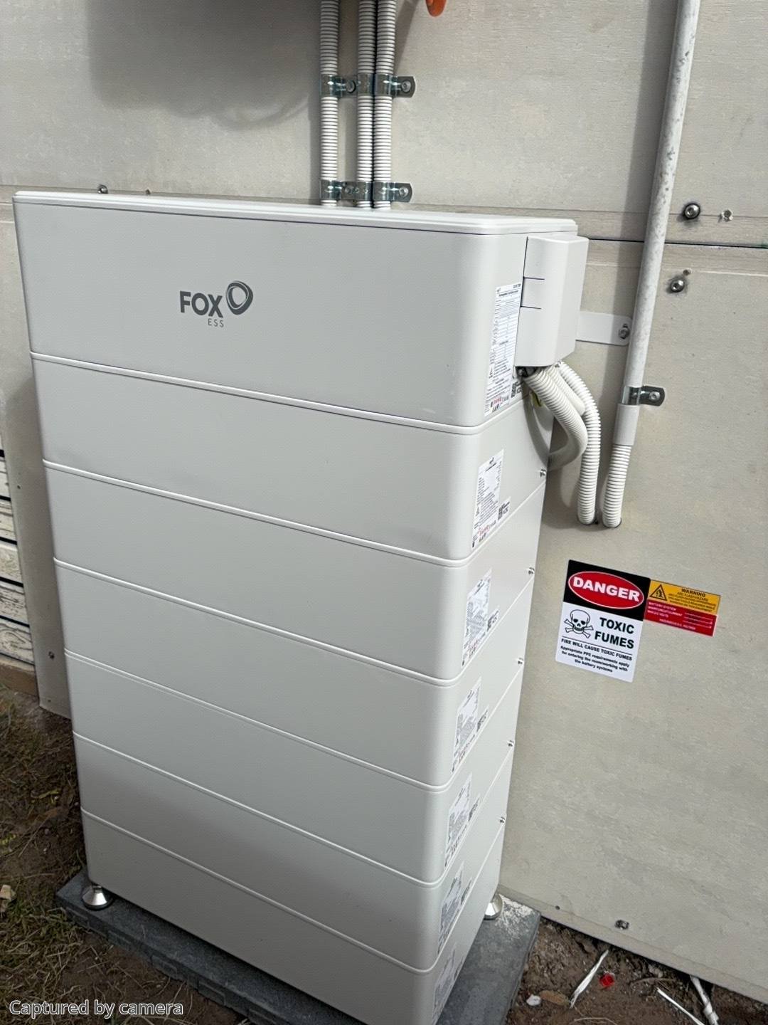 Stacked Fox ESS home battery installed outdoors against a rendered wall, Ellalong NSW